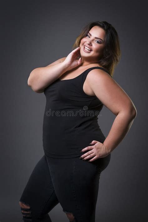 happy plus size fashion model in casual clothes fat woman on gray background overweight female