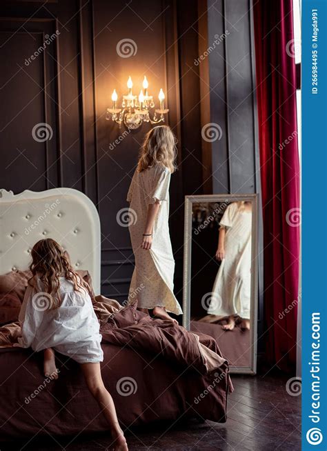 Girls Two Blondes With Long Hair Play In The Bedroom Stock Image
