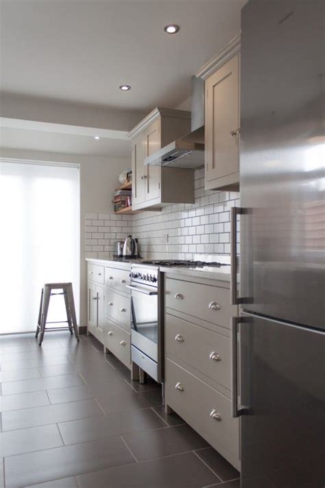 Inspiration for a tropical galley dark wood floor open concept kitchen remodel in other with an undermount sink, beaded inset cabinets, white cabinets, gray backsplash, stainless steel appliances, an island and green countertops A galley with style | Galley kitchen design, Devol kitchens, Shaker kitchen