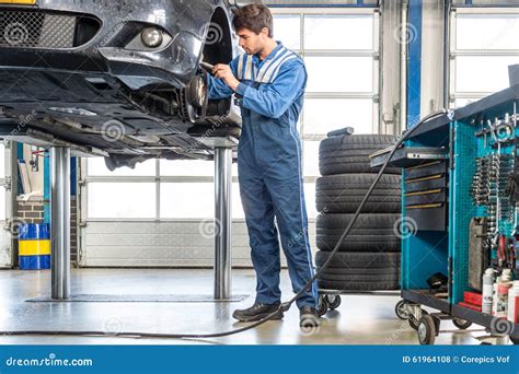 Mechanic Repairing Car On Hydraulic Lift Stock Photo Image Of