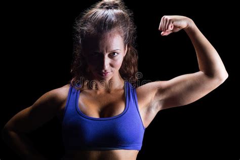 Portrait Of Confident Female Athlete Flexing Muscles Stock Photo
