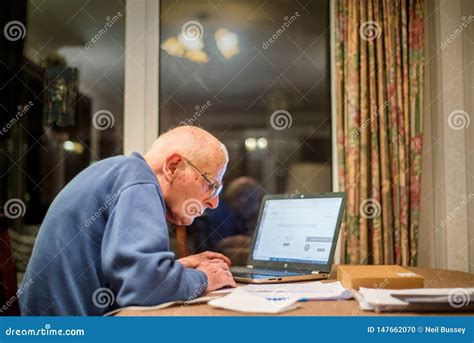 Elderly Man Using A Laptop Computer To Check His Finances Hampshire
