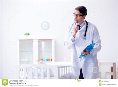 The Man Male Pediatrician Near Baby Bed Preparing To Examine Stock