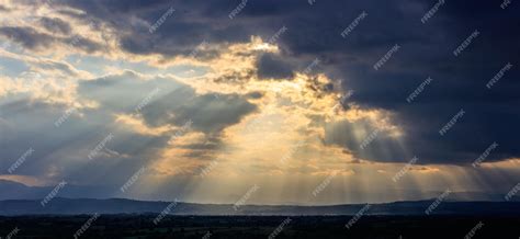 Premium Photo Stormy Clouds With Radiating Sunbeams Above Countryside