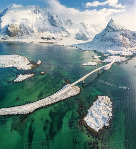 Aerial Panoramic View Of Snowy Peak Of Volanstinden And Fredvang Bridge