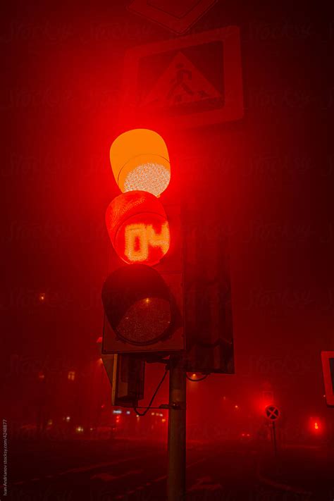 Red Traffic Light Signal On City Street At Night By Stocksy