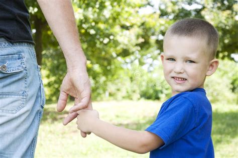 Padre E Hijo Que Llevan A Cabo Las Manos Que Caminan En El Parque