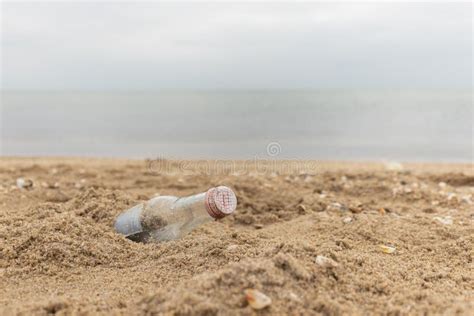 Empty Glass Bottle On The Sand Garbage On The Beach Sea Shore