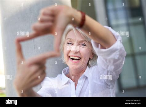 Portrait Of Laughing Mature Woman Shaping Frame With Her Fingers Stock