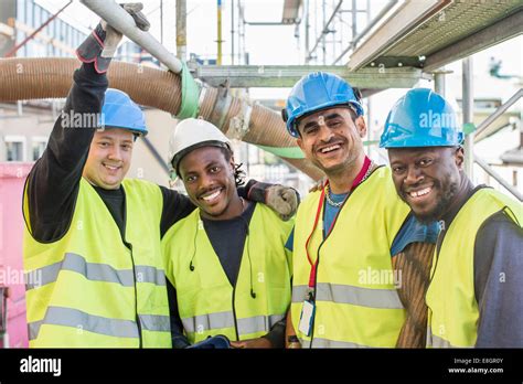 Portrait Of Happy Construction Workers Standing Together At Site Stock