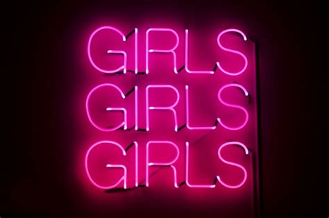 Girls Girls Girls Sign Glows In Racy Pink Neon Against Dark Night