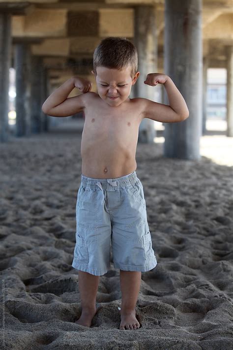 Babe Babe Flexing His Muscles On The Beach By Stocksy Contributor Dina Marie Giangregorio