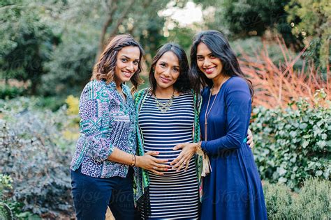 Beautiful Sisters Touching The Pregnant Belly Of Their Little Sister By Stocksy Contributor