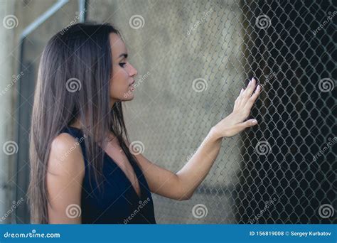 Young Beauty Woman Posing Over Metal Fence Background Stock Photo