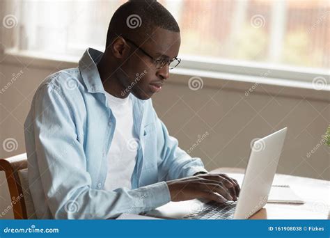 Serious Concentrated Young African American Man Working Remotely With