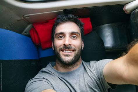 Young Man Selfie Lying Down On The Back Seat Of A Bus While Traveling By Stocksy Contributor