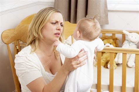 Stressed Mother Holding Baby In Nursery — Stock Photo © Monkeybusiness