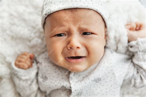 Premium Photo Newborn Crying Baby Girl Laying On White Blanket Tired