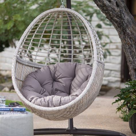 A cute contemporary hanging chair in the form of a net resembling a half of egg crafted of durable white ropes. Belham Living Palma Resin Wicker Hanging Egg Chair with ...