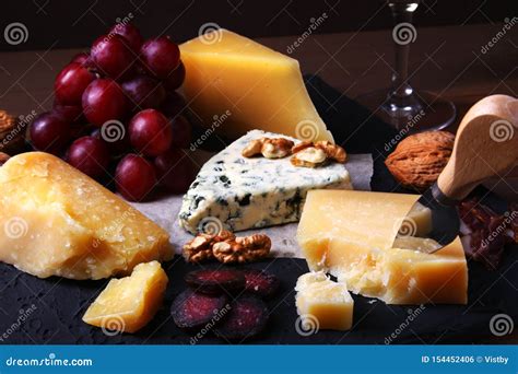 Assorted Cheeses Nuts Grapes Fruits Smoked Meat And A Glass Of Wine