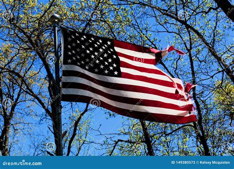 American Flag Blowing In The Wind With Blue Sky Background Stock Image
