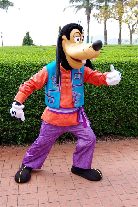 Goofy The Dog Mascot Standing In Front Of A Hedge