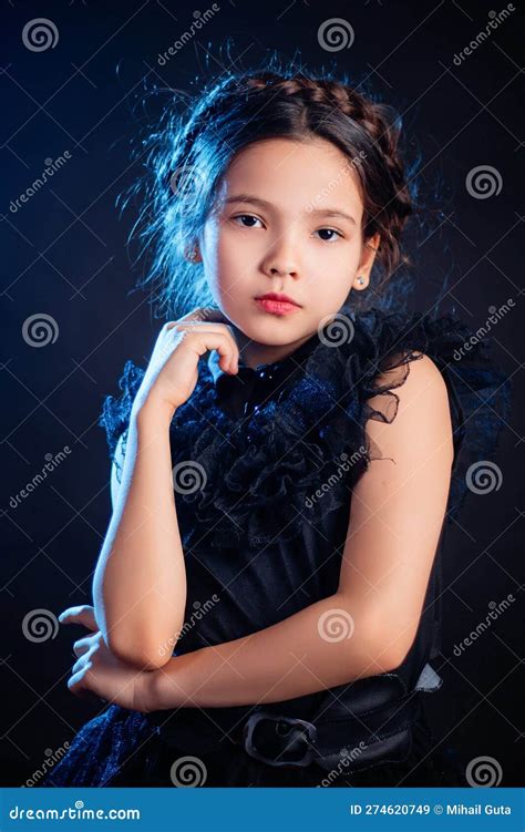 Portrait Of A Little Girl In A Black Dress With A Pigtail Hairstyle On