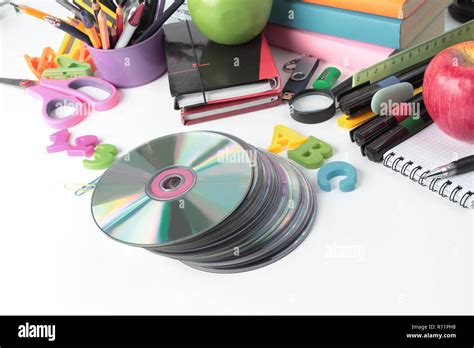 Stack Of Cds And School Supplies Isolated On White Backgroundphoto