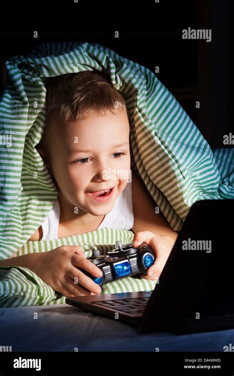 Young Five Years Old Boy Hiding From Mom Under Blanket Playing Computer
