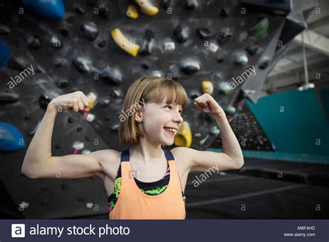 Confident Strong Tough Smiling Girl Rock Climber Flexing Muscles At
