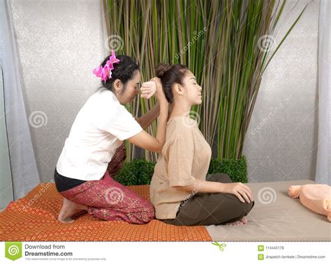 Professional Therapist Giving Traditional Thai Massage To A Woman In