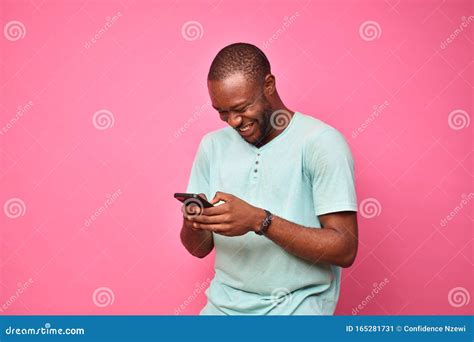 Young African Man Looking Very Excited While Using His Cellphone Stock