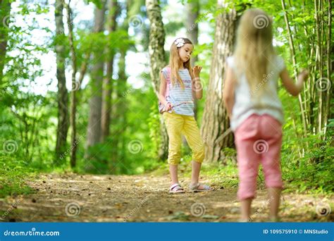 Two Cute Little Sisters Having Fun During Forest Hike On Beautiful