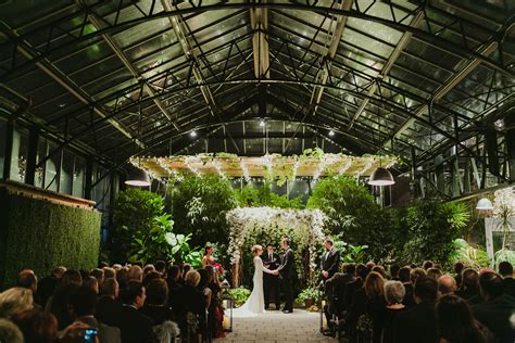 Romantic Greenhouse Wedding Ceremony With Lush Foliage Backdrop