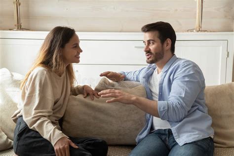 Happy Millennial Couple Talk Relaxing In Living Room Stock Image