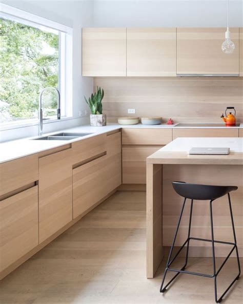 Look at how neat this kitchen is with a black countertop and wooden cabinets everywhere around it and it sits under a mezzanine. 15 Trendy-Looking Modern Wood Kitchens - Shelterness
