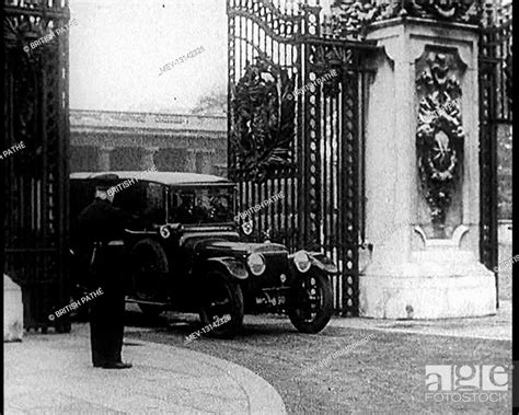 a uniformed male and a male british police officer standing outside the gates of buckingham