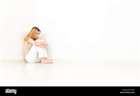 Sad Woman Is Hugging Her Knees She Is Sitting On The Floor And Barefoot Concept Of Loneliness