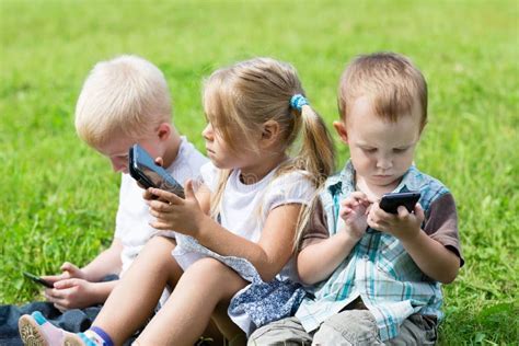 Glückliche Kinder Die Auf Smartphones Spielen Stockfoto Bild Von