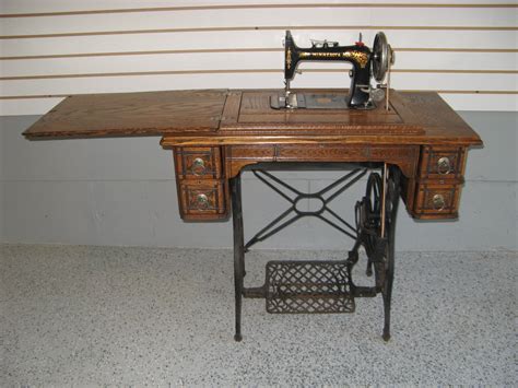 An Old Sewing Machine Sitting On Top Of A Wooden Table Next To A White Wall