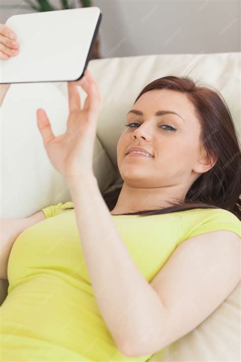 premium photo happy teen girl lying on sofa using a tablet pc