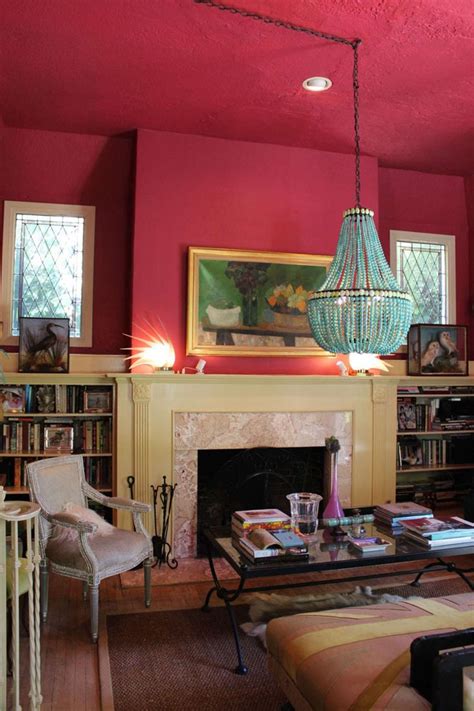 A Living Room With Red Walls And A Chandelier Hanging From The Ceiling