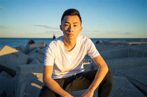 Portrait Of Young Asian Man Sitting And Looking At Camera — Rubber