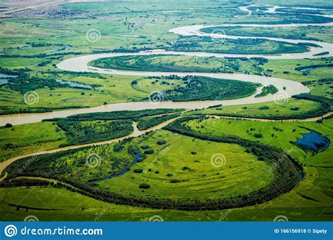 View Of The Valley Of A Meandering River Among Green Fields And Forests