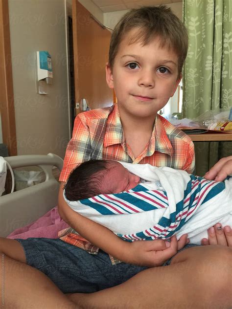 Big Brother Holding His Baby Brother For The First Time By Stocksy Contributor CWP LLC