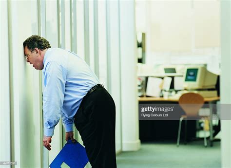Frustrated Businessman Banging His Head Against A Brick Wall In The