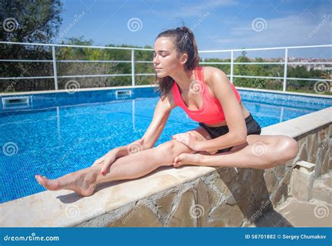 Attractive Brunette Woman Doing Stretching Exercise Near Swimmin Stock