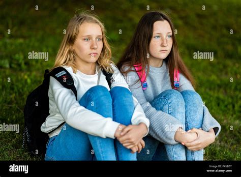 For Girl Schoolgirl Summer In Nature They Are Sitting On Grass Behind Backpacks Rest After