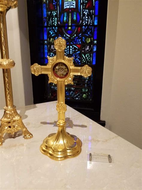 A Golden Cross And Candle Holder On A Table