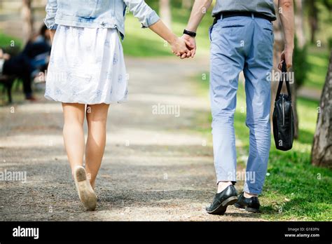 Couple Of People Holding Hands While Walking In Park Stock Photo Alamy